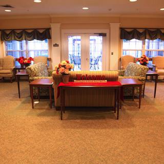 A cozy lobby area with comfortable seating, decorated with flowers and lamps.