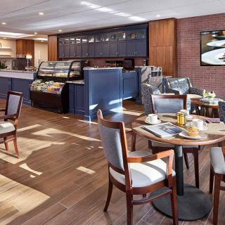 A modern cafe with various seating arrangements and a display counter.