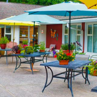 A vibrant outdoor seating area adorned with colorful umbrellas and potted plants, perfect for enjoying a sunny day.