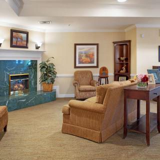 A cozy living room with traditional decor, featuring comfortable armchairs and a fireplace.