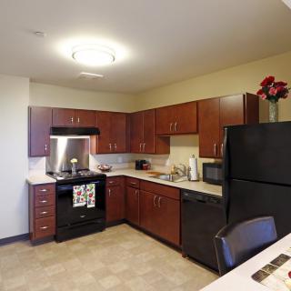A modern kitchen with wooden cabinets and standard appliances.