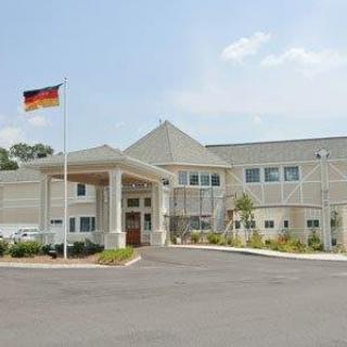 A modern building with a flag at the entrance on a clear day.