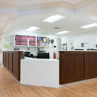 A modern office reception area featuring wooden counters and a clean design.