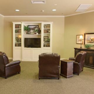 A cozy living room with leather seating and a built-in entertainment center.
