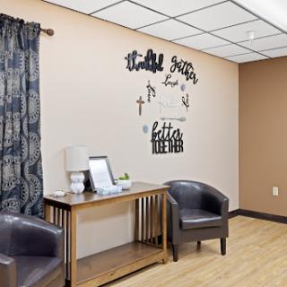 A cozy waiting area featuring stylish chairs and decorative wall art.