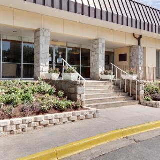 A modern building entrance featuring stone pillars and landscaped surroundings.