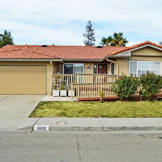 A suburban house with a two-car garage, front yard, and a small porch.