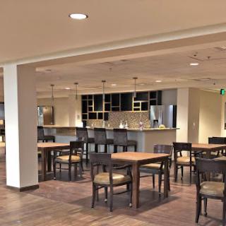 A spacious and modern dining area featuring wooden tables and a bar.