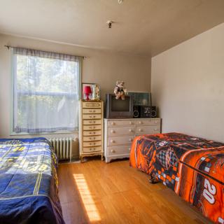 A cozy bedroom featuring two beds and ample natural light.