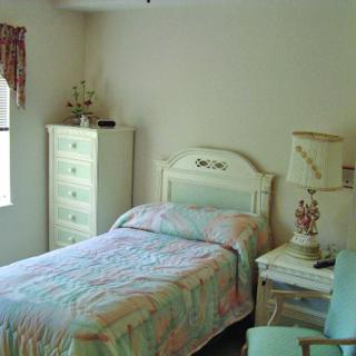 A cozy bedroom with a single bed, dresser, and matching furniture.