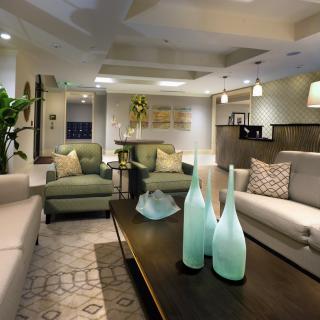 A modern living room with stylish furniture and elegant decor, featuring glass vases on a wooden coffee table.