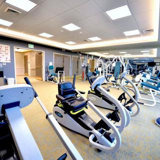 A spacious gym filled with exercise machines and fitness equipment.