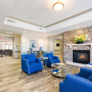 A cozy and modern living room featuring blue chairs and a charming fireplace.