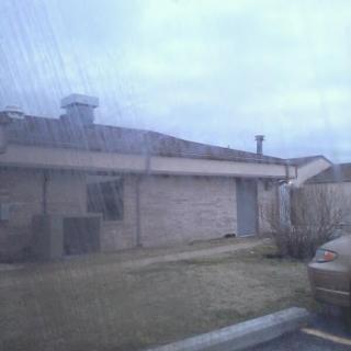 A cloudy day view of a residential building with a parked car.