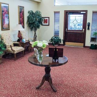 A welcoming lobby area with a round table, floral centerpiece, and seating.