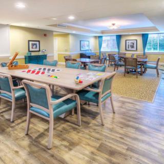 A spacious and well-lit game room with tables and chairs arranged for activities.