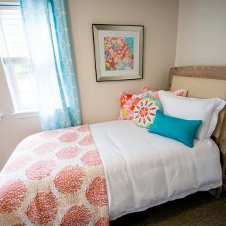 A cozy bedroom with colorful throw pillows and vibrant decor.