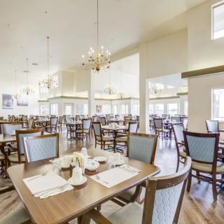 A spacious, elegantly designed dining area with neatly arranged tables and chairs.