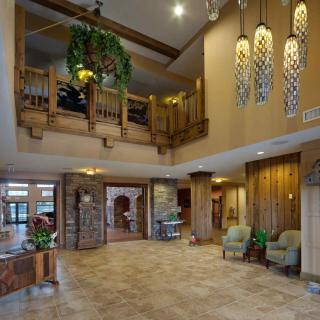 A spacious hotel lobby with wooden decor and elegant chandeliers.