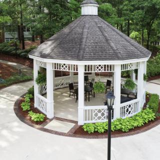A picturesque gazebo surrounded by greenery in a garden setting.