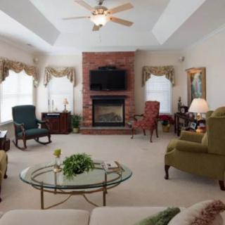 A cozy living room featuring a fireplace, TV, and elegant furniture.