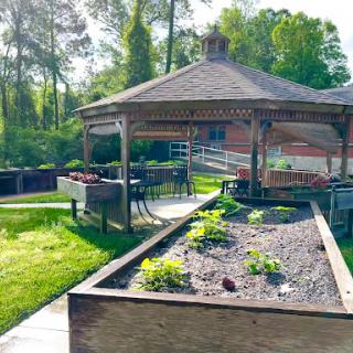 A serene garden space featuring a gazebo and well-maintained vegetable beds.