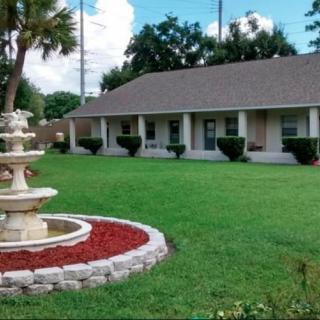 A suburban house with a well-maintained lawn and decorative fountain.