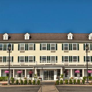 A large, traditional-style hotel building with multiple windows and a clear blue sky in the background.