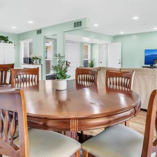 A spacious dining room with a wooden table and chairs, seamlessly connected to an open living area.