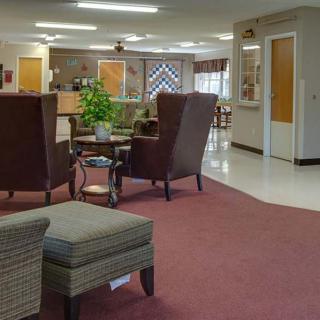 A comfortable waiting area with chairs and a reception desk in the background.