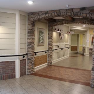 A well-lit hallway featuring a combination of stone and wooden accents.