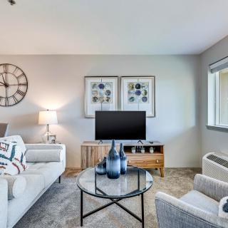 A modern living room with stylish decor, featuring a sofa, coffee table, and television.