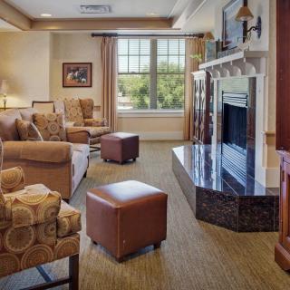 A cozy living room featuring a sofa, armchairs, and a fireplace.