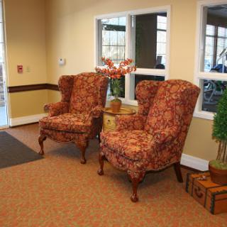 A cozy seating area featuring a pair of vintage upholstered chairs with floral patterns, set in a warmly lit room.