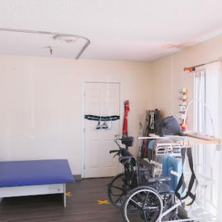 A spacious room featuring a bed and a wheelchair, designed for accessibility.