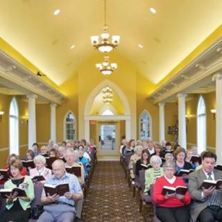 A congregation gathered inside a church, singing from hymnals.