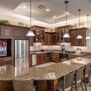 A modern kitchen with wooden cabinets, a curved countertop, and bar stools.