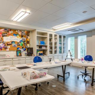 A bright and organized art studio with tables and supplies ready for creativity.