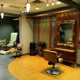 A stylish hair salon interior with comfortable chairs and large mirrors.