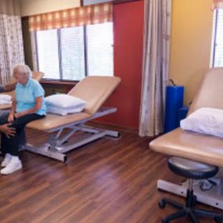 A rehabilitation clinic with a focus on elderly care, featuring treatment tables and equipment.