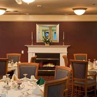 A cozy dining area featuring elegantly set tables and a warm fireplace.