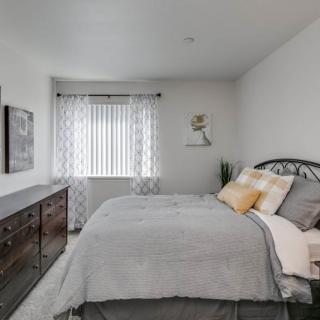 A modern bedroom with a comfortable bed, stylish furniture, and light decor.