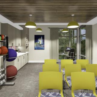 A modern conference room with yellow chairs and a small kitchen area featuring basketballs for decoration.