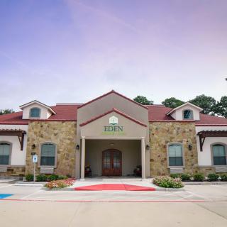 A charming building with stonework and a red roof under a clear sky.