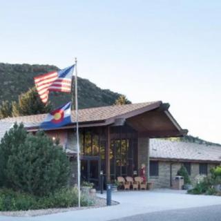 A building with American and state flags, set against a mountainous backdrop.