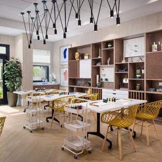 A modern dining room with yellow chairs, pendant lighting, and wooden flooring.