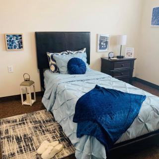 A cozy bedroom with blue-themed decor and a neatly made single bed.