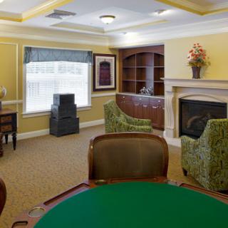 A cozy living room setting featuring a fireplace and green upholstered chairs, ideal for relaxation and social games.