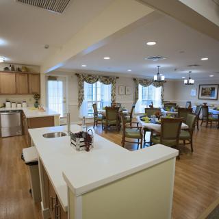 A spacious open-plan kitchen and dining area with modern furnishings and ample lighting.