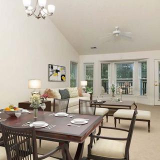 A spacious and well-lit living and dining area featuring modern furniture.